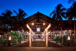 a building with stairs and palm trees at night at Sheraton Senggigi Beach Resort in Senggigi