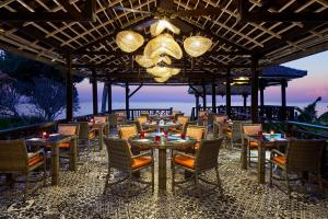 a restaurant with tables and chairs and a chandelier at Sheraton Senggigi Beach Resort in Senggigi