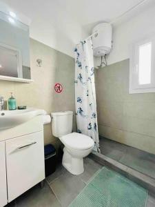 łazienka z toaletą i zasłoną prysznicową w obiekcie Cozy, newly renovated apartment in Gavrio. w mieście Gavrion