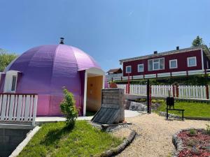 Ein lila Kuppelhaus mit einer Bank im Garten in der Unterkunft Dirndlhaus in Kirchberg an der Pielach + 8 Fotos