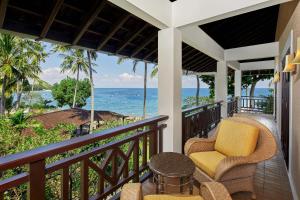 - un balcon avec deux chaises et une table donnant sur l'océan dans l'établissement Sheraton Senggigi Beach Resort, à Senggigi