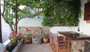 a patio with a table and chairs and plants at Villa Nefeli Rhodes in Archangelos