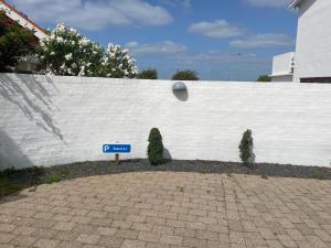 ein Parkschild vor einer weißen Wand in der Unterkunft Lejlighed Edelweiss in Svendborg
