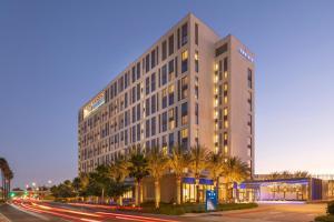 a tall building with palm trees in front of a street at The Viv Hotel, Anaheim, a Tribute Portfolio Hotel in Anaheim