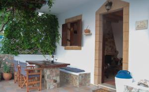 patio ze stołem i krzesłami w domu w obiekcie Villa Nefeli Rhodes w mieście Archangelos