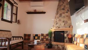 a living room with a couch and a fireplace at Villa Nefeli Rhodes in Archangelos