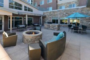 a patio with a fire pit and tables and chairs at Residence Inn by Marriott Coralville in Coralville