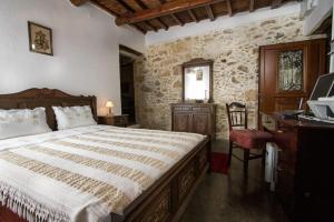 a bedroom with a bed and a desk and a window at Sofiana Traditional Villa with swimming pool in Drapaniás