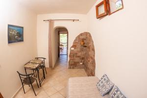 a living room with a table and a stone fireplace at Agriturismo Al Cappero in Malfa