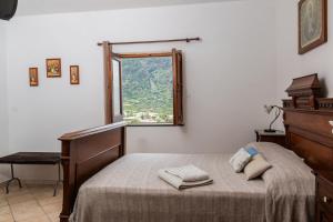 a bedroom with a bed and a desk and a window at Agriturismo Al Cappero in Malfa