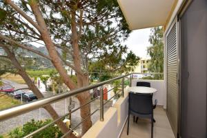 a balcony with a table and a tree at Hotel Aghas Paleochora in Palaiochora