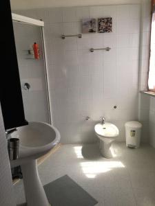 bagno bianco con servizi igienici e lavandino di Appartamento Bellavista a Castiglioncello