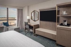 a hotel room with a bed and a desk and a television at Sheraton Dallas Hotel by the Galleria in Dallas