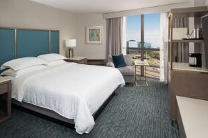 a hotel room with a large bed and a large window at Sheraton Dallas Hotel by the Galleria in Dallas