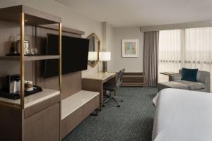 a hotel room with a bed and a desk at Sheraton Dallas Hotel by the Galleria in Dallas