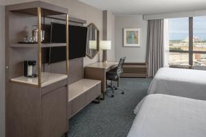 a hotel room with a bed and a desk at Sheraton Dallas Hotel by the Galleria in Dallas