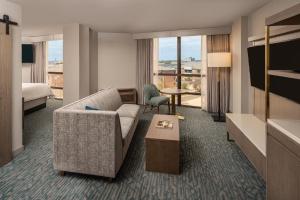 a hotel room with a couch and a bed at Sheraton Dallas Hotel by the Galleria in Dallas
