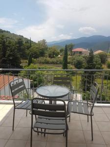 una mesa y sillas en un balcón con vistas en Eva's apartments, en Nafpaktos