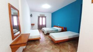 a blue room with two beds and a mirror at Blue Sand 2 in Masouri