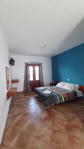 a bedroom with a bed with a blue wall at Blue Sand 2 in Masouri +2 photos