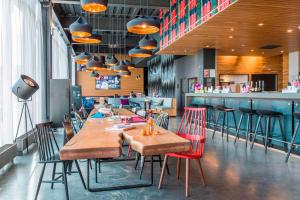 a restaurant with tables and chairs and a bar at Moxy Aberdeen Airport in Dyce
