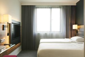 a hotel room with two beds and a window at Moxy Aberdeen Airport in Dyce