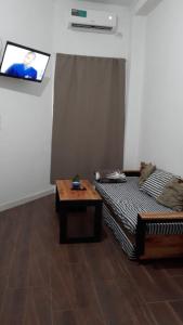 Habitación con cama, mesa y TV. en Alojamientos temporarios Isabela en Posadas