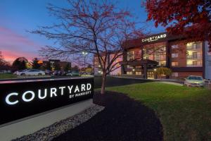 Courtyard by Marriott Cincinnati Airport في إيرلانغر: لافته امام مبنى مع وكالة سيارات
