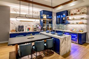 a kitchen with blue cabinets and a large table with chairs at Sheraton Nashua in Nashua