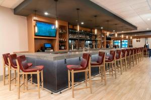 a bar with a row of bar stools in a restaurant at Delta Hotels by Marriott Kalamazoo Conference Center in Kalamazoo