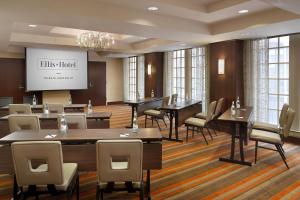 a conference room with tables and chairs and a screen at Ellis Hotel, Atlanta, a Tribute Portfolio Hotel in Atlanta