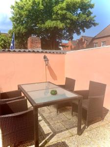 ein Glastisch und Stühle auf einer Terrasse in der Unterkunft Alt-Emder Bürgerhaus in Emden