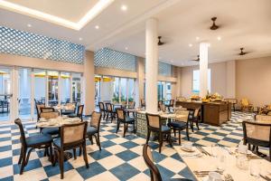 a dining room with tables and chairs and windows at Ermita Cartagena, a Tribute Portfolio Hotel in Cartagena de Indias