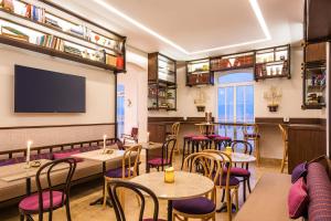 a restaurant with tables and chairs and a flat screen tv at Ermita Cartagena, a Tribute Portfolio Hotel in Cartagena de Indias