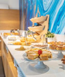 a buffet line with cakes and desserts on plates at Hotel Rudy in Riva del Garda