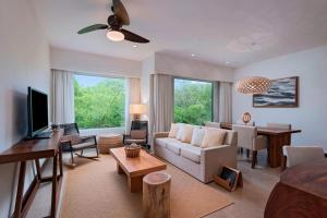 a living room with a couch and a tv at El Mangroove Papagayo, Autograph Collection in Papagayo, Guanacaste