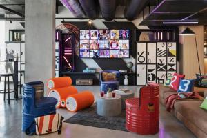 a living room with orange and blue chairs and a couch at Moxy La Ciotat in La Ciotat