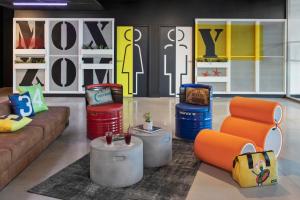 a living room with a couch and ottoman at Moxy La Ciotat in La Ciotat
