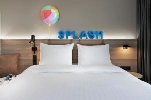 a bed with a balloon and a sign that readssplash at Moxy La Ciotat in La Ciotat