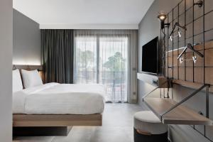 a hotel room with a bed and a television at Moxy La Ciotat in La Ciotat