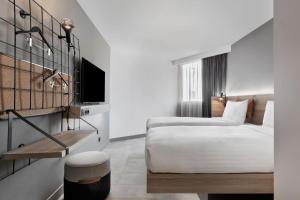 a hotel room with two beds and a tv at Moxy La Ciotat in La Ciotat