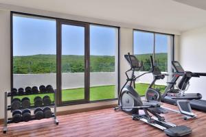 a gym with two tread machines and large windows at Courtyard by Marriott Mahabaleshwar in Mahabaleshwar