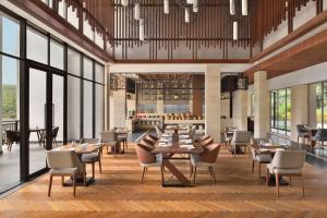 a rendering of a restaurant with tables and chairs at Courtyard by Marriott Mahabaleshwar in Mahabaleshwar