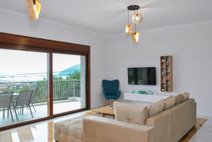 - un salon avec un canapé et une télévision dans l'établissement Villa Oliveto con vista, à Leucade