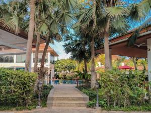 ein Resort mit Palmen neben einem Pool in der Unterkunft Rawai Grand House -SHA Plus in Rawai Beach