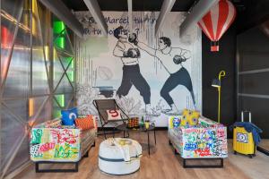 a room with a wall with a mural of two men at Moxy La Ciotat in La Ciotat