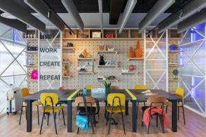 a dining room with tables and yellow chairs at Moxy La Ciotat in La Ciotat