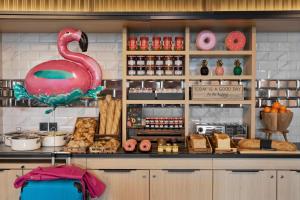 a bakery with a large pink flamingo on the counter at Moxy La Ciotat in La Ciotat