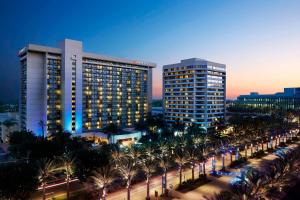 a view of two tall buildings and palm trees at night at Anaheim Marriott in Anaheim