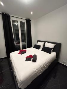 una camera da letto con un grande letto bianco con cuscini neri e rossi di Luxury Monaco ! 7 mins walk to casino square ! Yacht show ! F1 ! 15 sec to Monaco ! a Beausoleil